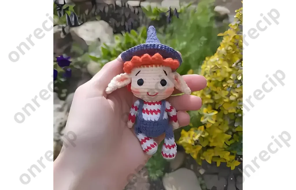 A small crocheted elf amigurumi in five colors